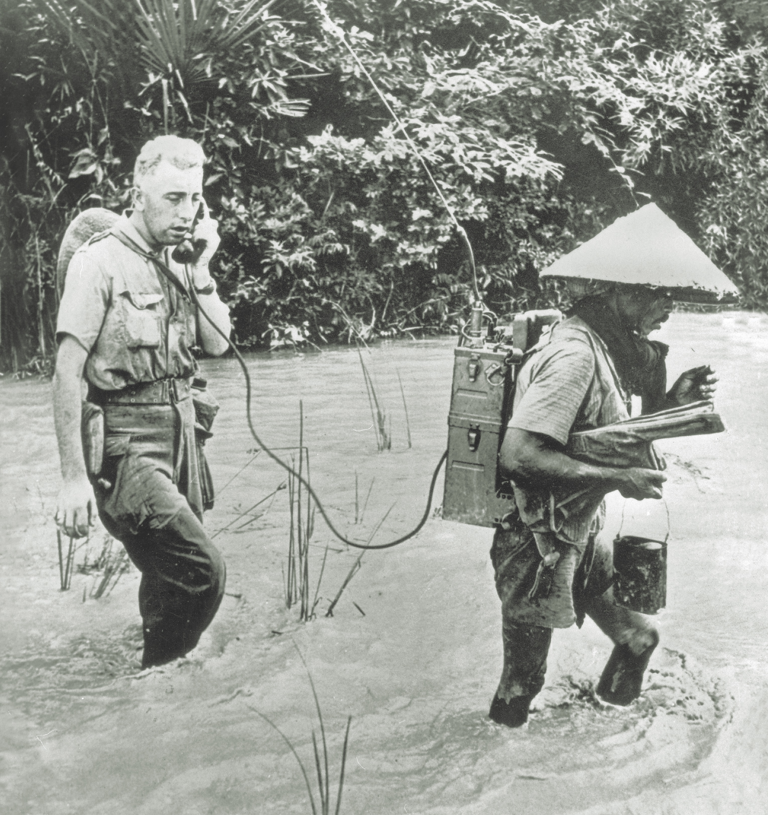 A French Foreign Legion officer radios a situation report as he and his radio bearer cross a swollen stream. (Ullstein Bild, Getty Images) 