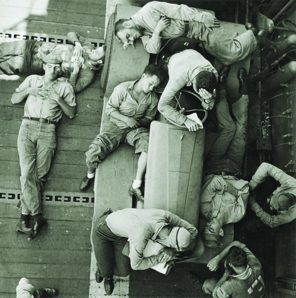 Crewmen relax on Hornet’s flight deck as they await the return of aircraft to the carrier—then steaming toward the Mariana Islands. Fighters from the Hornet and other carriers would soon face and wipe out waves of Japanese aircraft in a series of June 19, 1944, battles that became known as the “Great Marianas Turkey Shoot.” (Charles E. Kerlee/U.S. Navy)