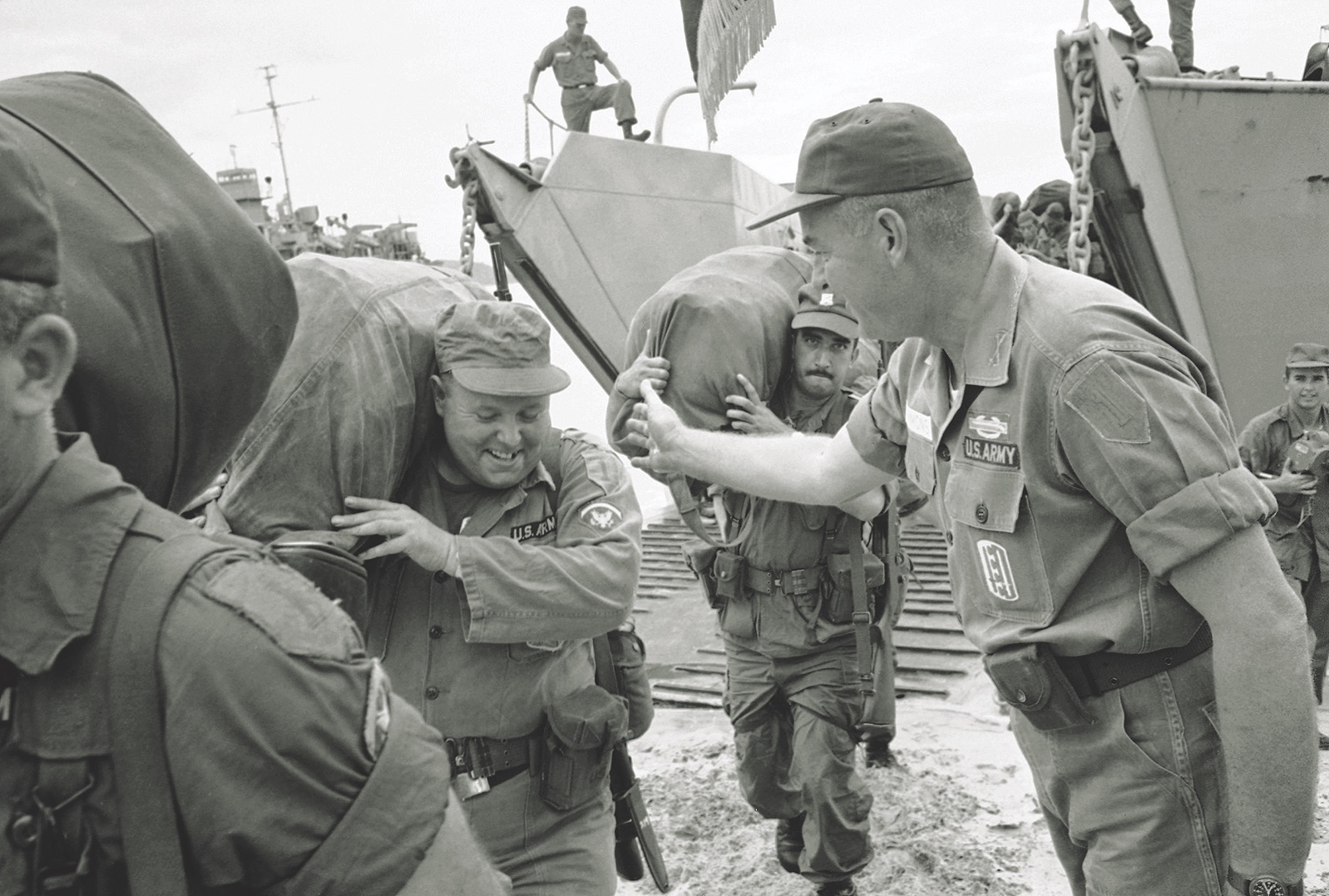 Col. James E. Simmons of the 1st Infantry Division’s 2nd Brigade gives a pat on the back to a soldier landing at Cam Ranh Bay. (AP Photo/Horst Faas)