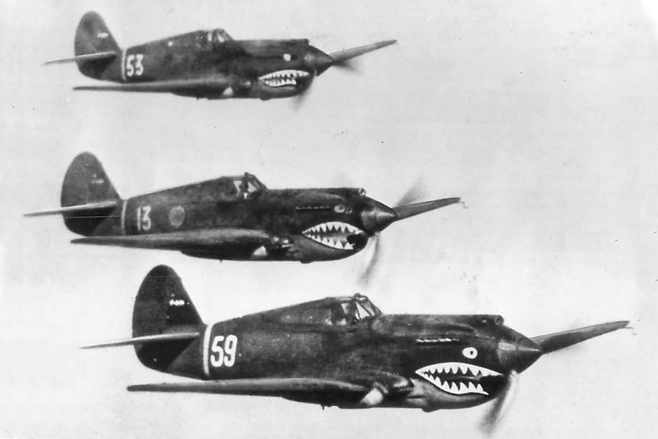 Three P-40s fly in formation, on the prowl for enemy aircraft. “Flying Tiger” no. 13 displays the 1st Pursuit Squadron’s green apple insignia showing Adam chasing Eve, the "first pursuit.” (National Archives)