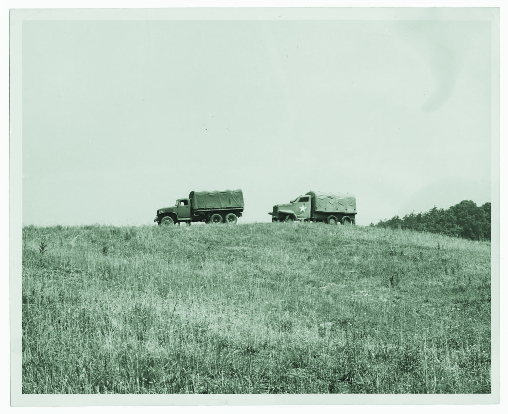 This pair of trucks exemplifies effective work from the artist duo in the previous sketch: the truck on the far left is a standard M35 cargo truck; that on the right, an inflatable fake. 