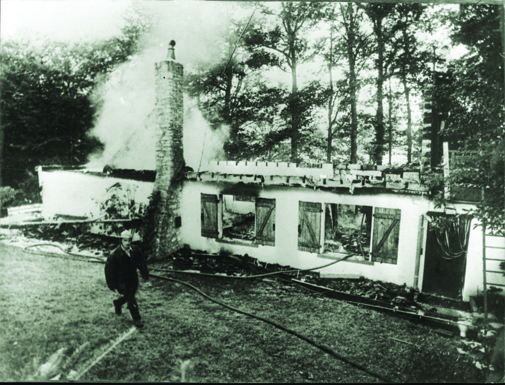 Peiper was 61 and living in France in 1976 (below) when unknown arsonists dealt their own form of justice, firebombing his house (above); Peiper died in the blaze. (Keystone Press/Alamy Stock Photo)