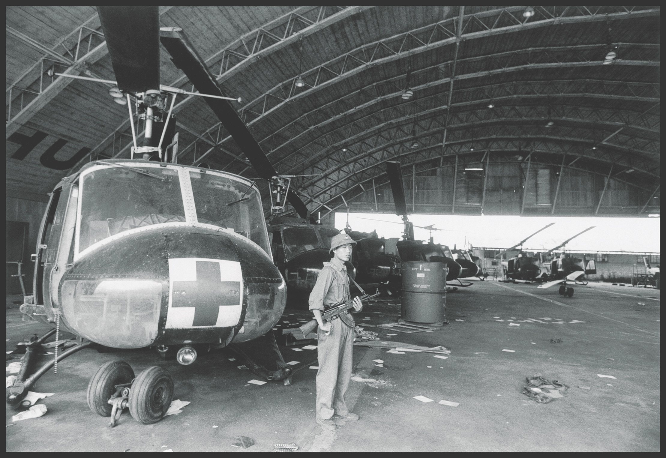 After Da Nang fell on March 29, 1975, a North Vietnamese Army soldier stands alongside the spoils of war, a broken-down American-made Huey helicopter. (A. Abbas/Magnam Photo)