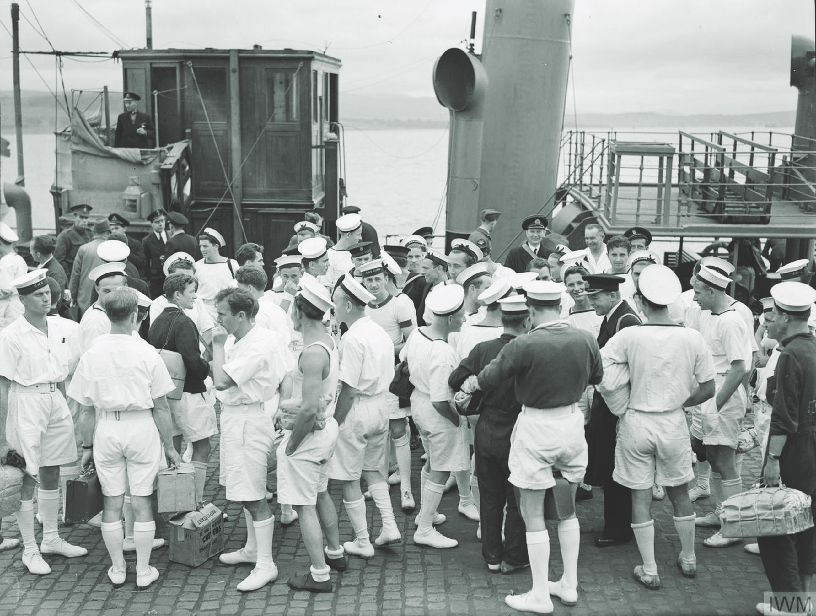 Wearing the tropical uniforms issued to them in the Mediterranean, Kujawiak survivors come ashore at Greenock, Scotland, on June 24, 1942. (Imperial War Museums)