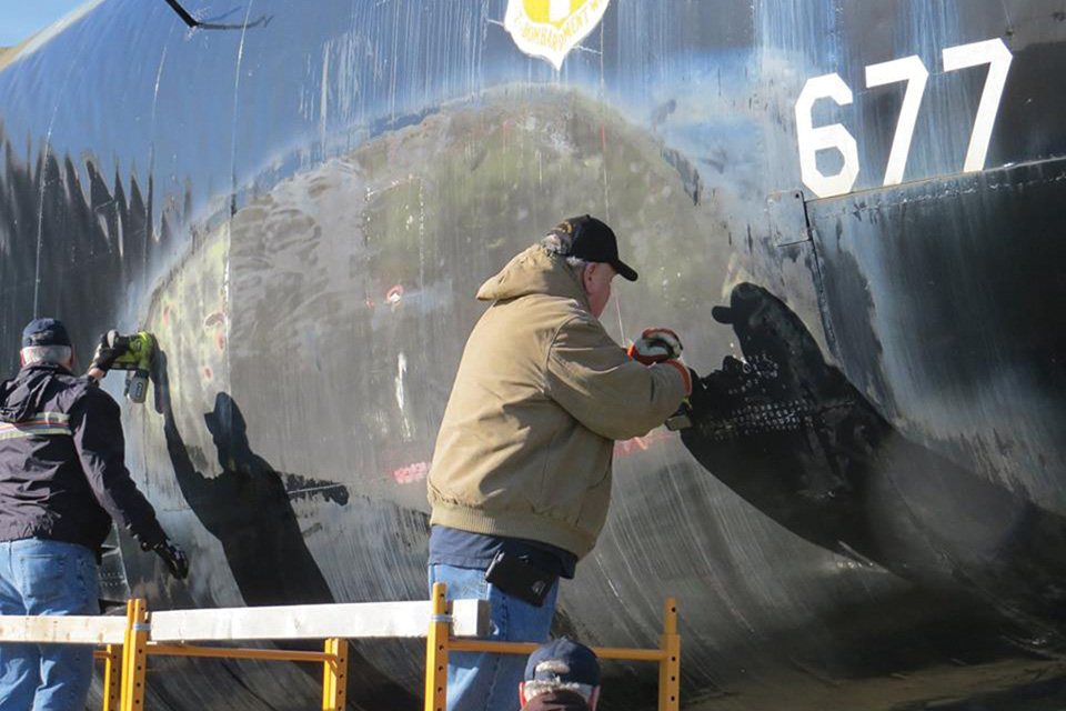 Two volunteers sand paint from 677’s fuselage. Plans call for the bomber to be repainted in its original Southeast Asia scheme. (Courtesy of Yankee Air Museum B-52 Preservation Team)