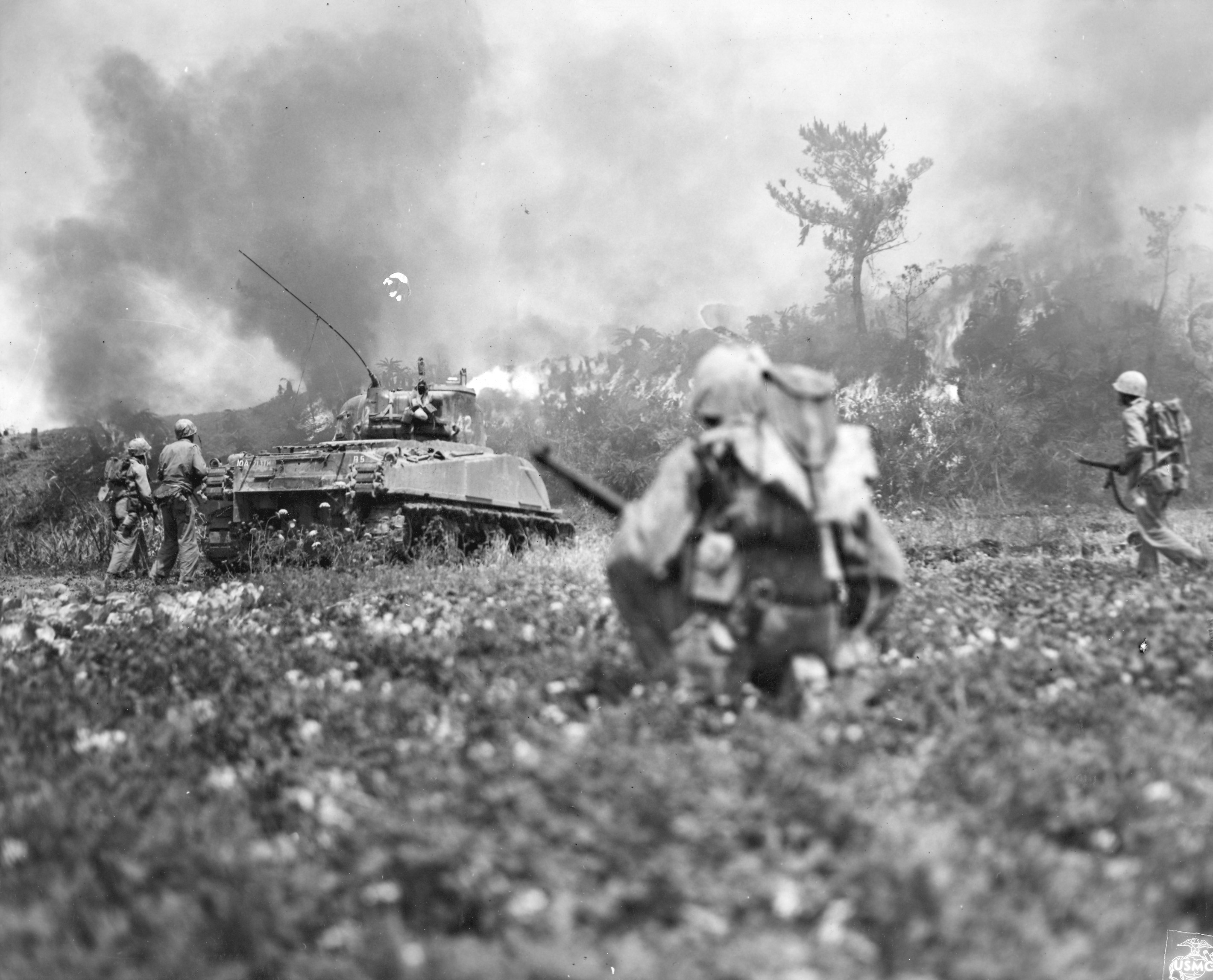 Marines move behind a flamethrowing tank on Okinawa. (USMC)