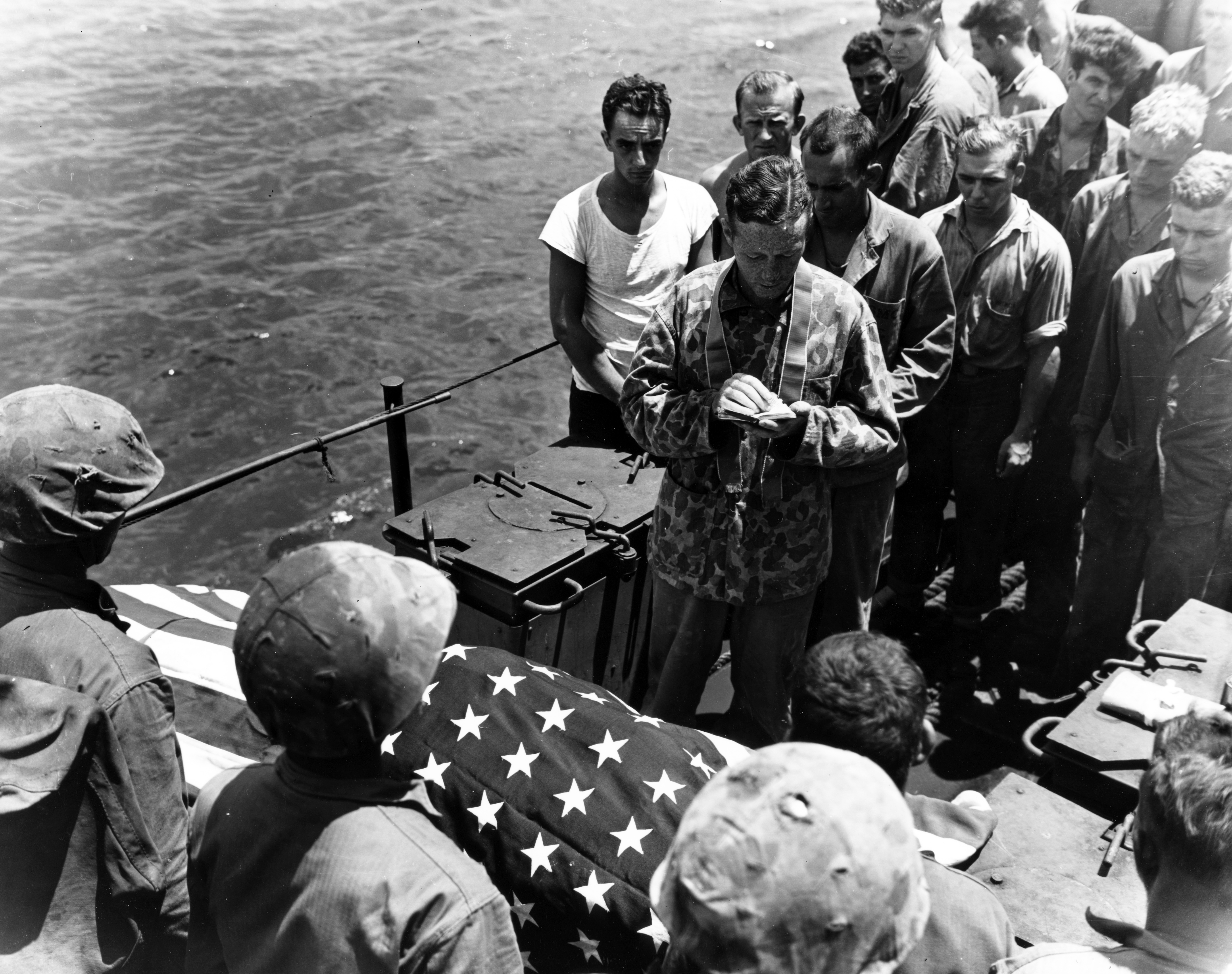 Chaplain Gallagher says mass over a dead Marine to be buried at sea. The Marine was killed during the assault on Tinian. (USMC)