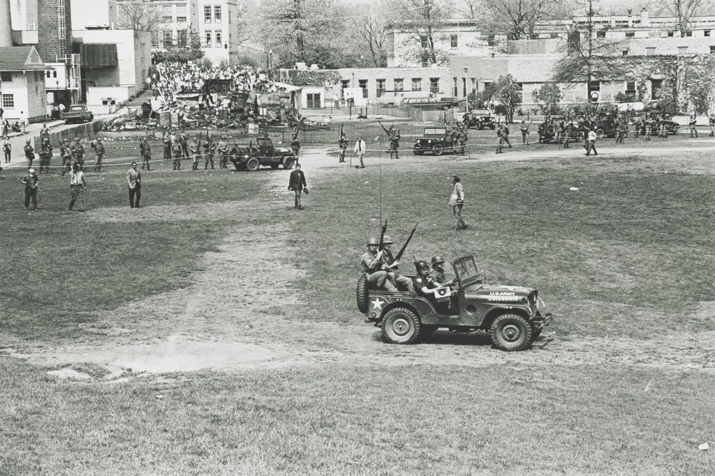 A university police officer with a bullhorn, bottom, rode in a National Guard jeep to order the students to disperse. (Kent State Digital Archives)