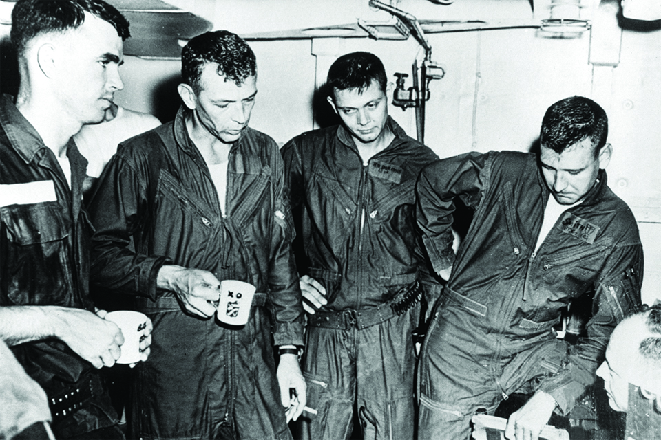 From left: Batson, Page, Doremus and J.C. Smith recount details of the mission for an intelligence officer. Their mugs contained “medicinal” brandy. (U.S. Navy via Batson)