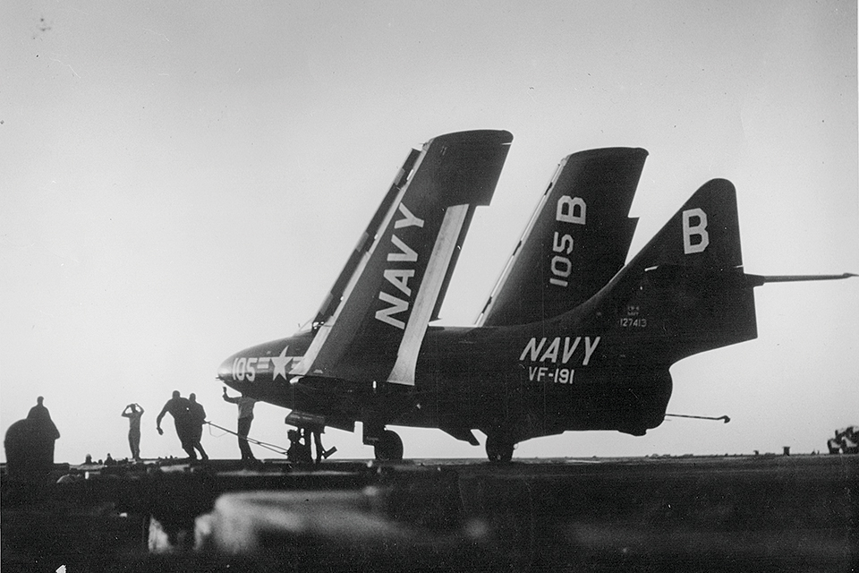 A Grumman F9F-6 Cougar is hauled into position.
