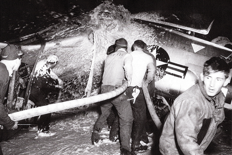 Deck crewmen hose down a crashed F2H Banshee with fire foam.