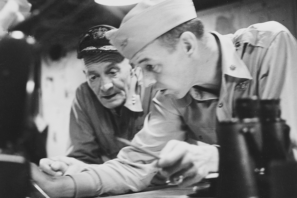 Vice Admiral John S. McCain (left) and his air operations officer, Commander Jimmy Thach, work a problem onboard USS Hancock. (Naval History and Heritage Command)