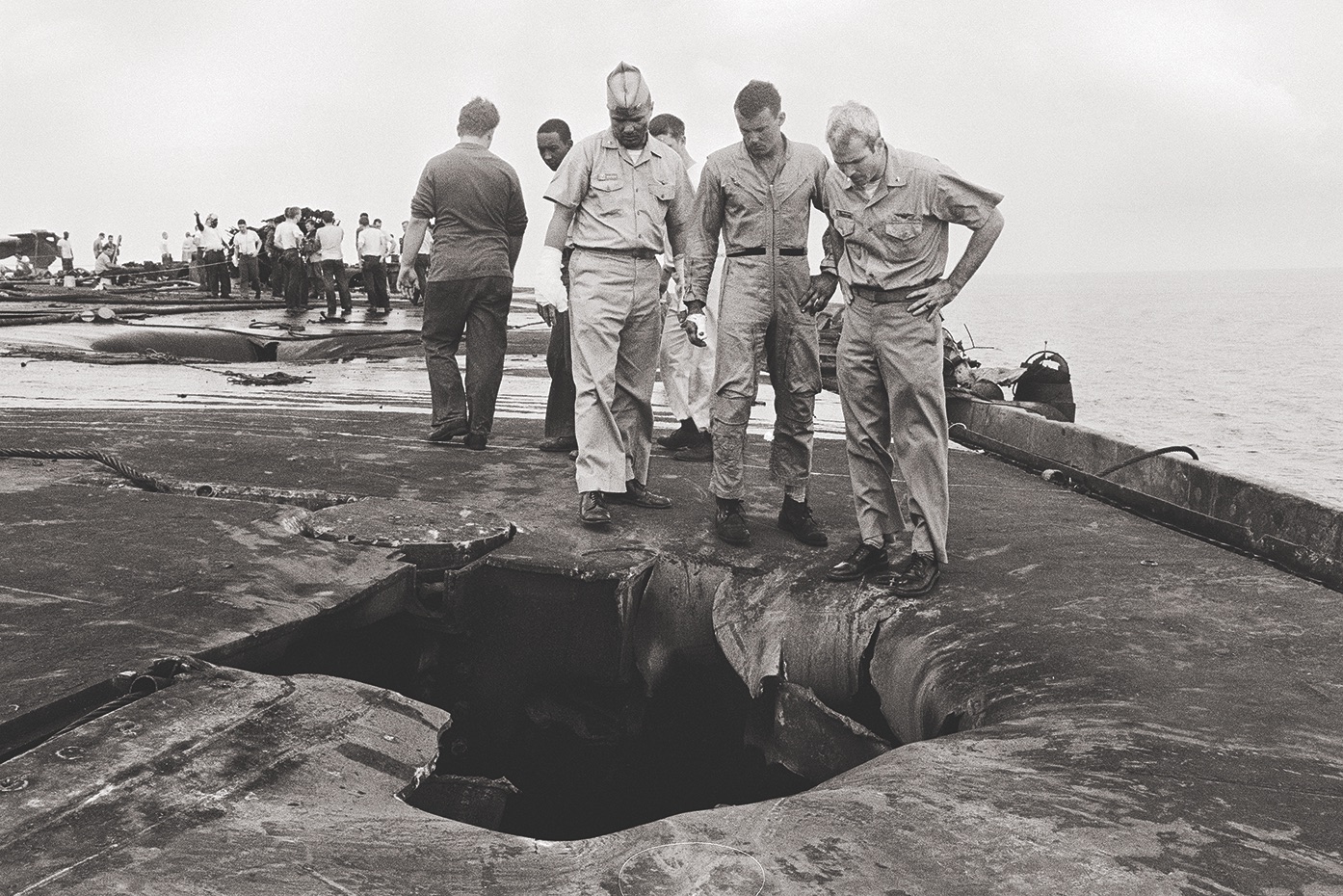 Surveying damage aboard the Forrestal, left, on July 30, 1967, is a group of pilots including Lt. Cmdr. John McCain (right) / Getty
