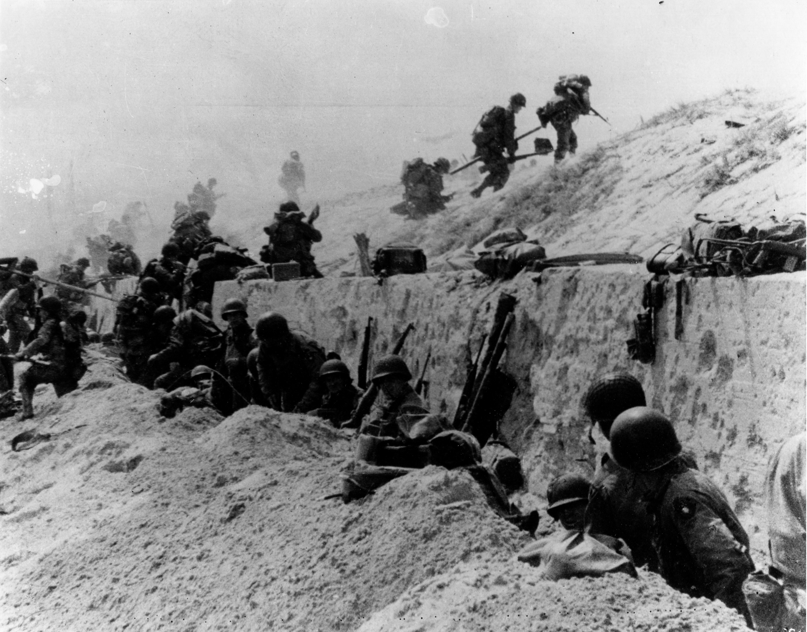 U.S. soldiers of the 4th Infantry Division move out over the seawall on Utah Beach. (Naval History and Heritage Command)