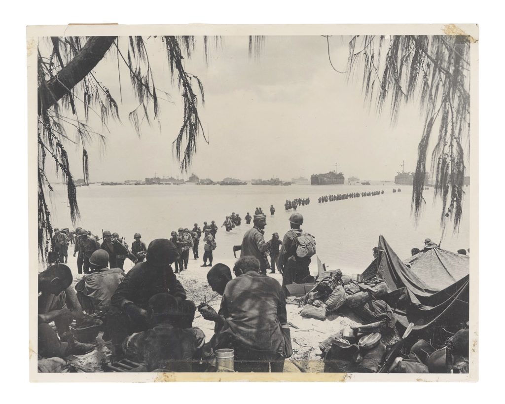 Reinforcements wade from their LSTs (Landing Ships, Tank) across a reef to a Saipan beach in June 1944. (The New York State Military Museum)