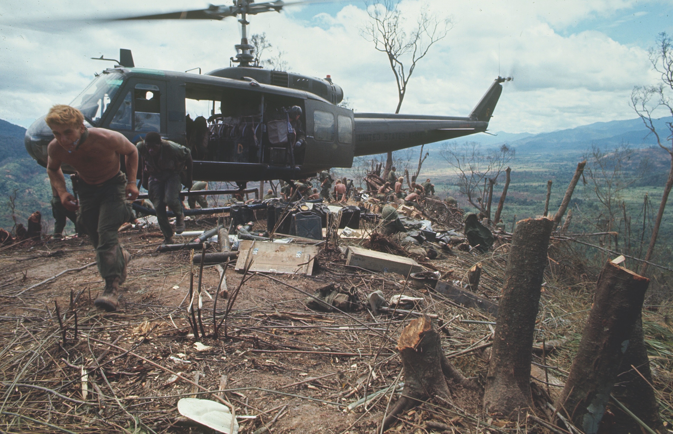 Soldiers rush from a Huey helicopter at an American outpost in the A Shau Valley in 1968. / Getty Images