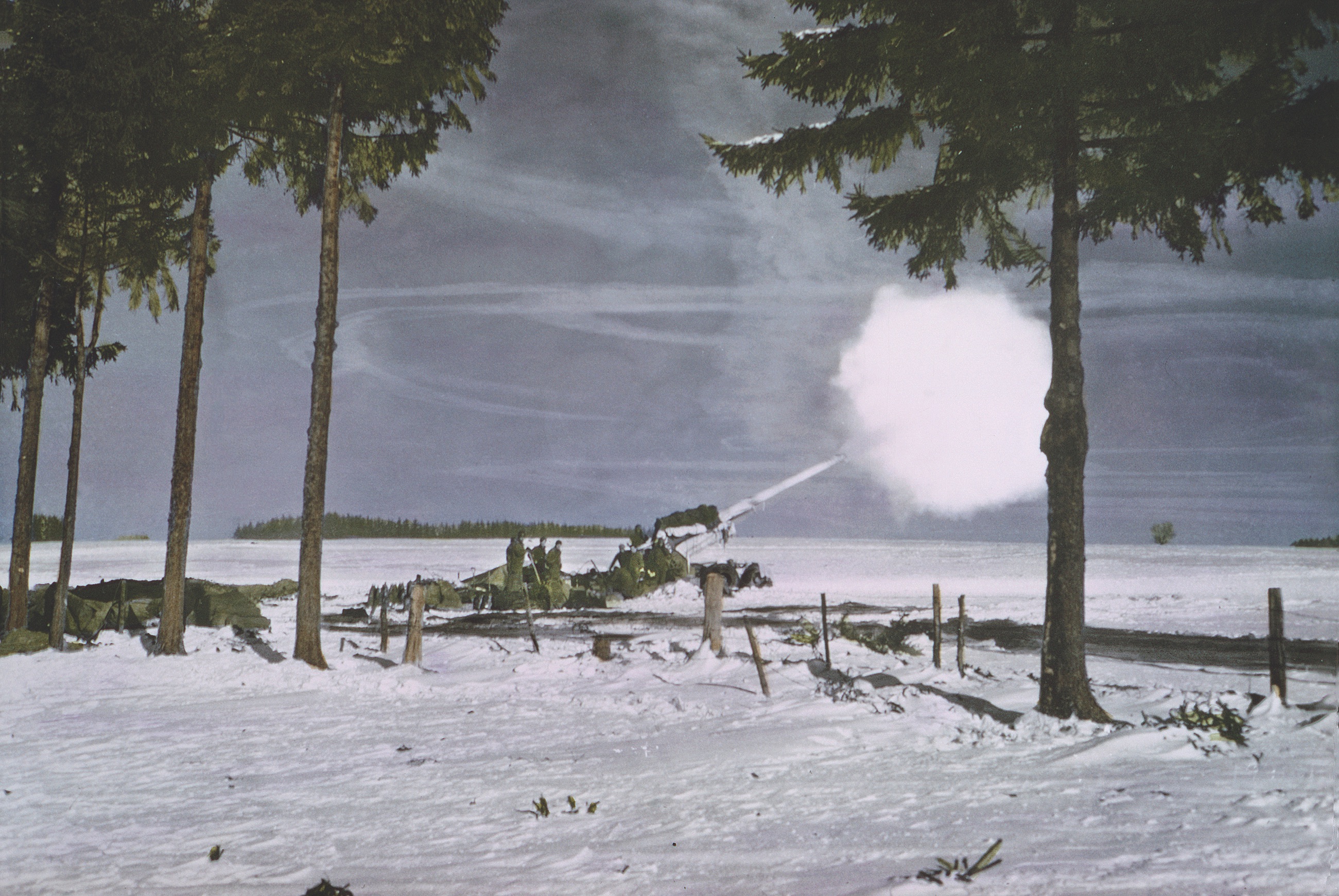 A U.S. 155 mm field gun fires VT-fuzed rounds at German forces during the 1944–45 Battle of the Bulge. / Getty Images