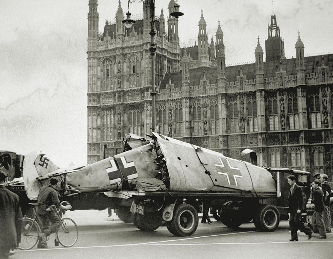 A downed Luftwaffe Bf 109 is paraded through London, with the Houses of Parliament in the background. / Getty Images