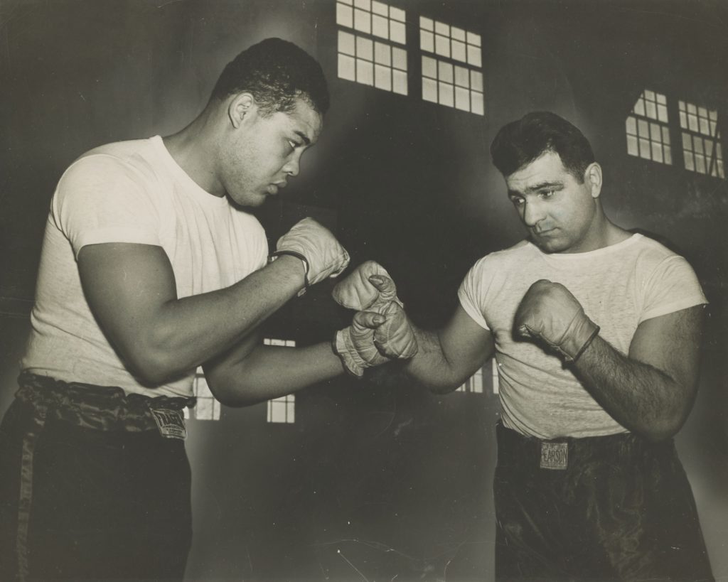 Heavyweight boxing champion Joe Louis (left) and former light-heavyweight champion Melio Bettina, both stationed at Camp Shanks, spar for the camera.