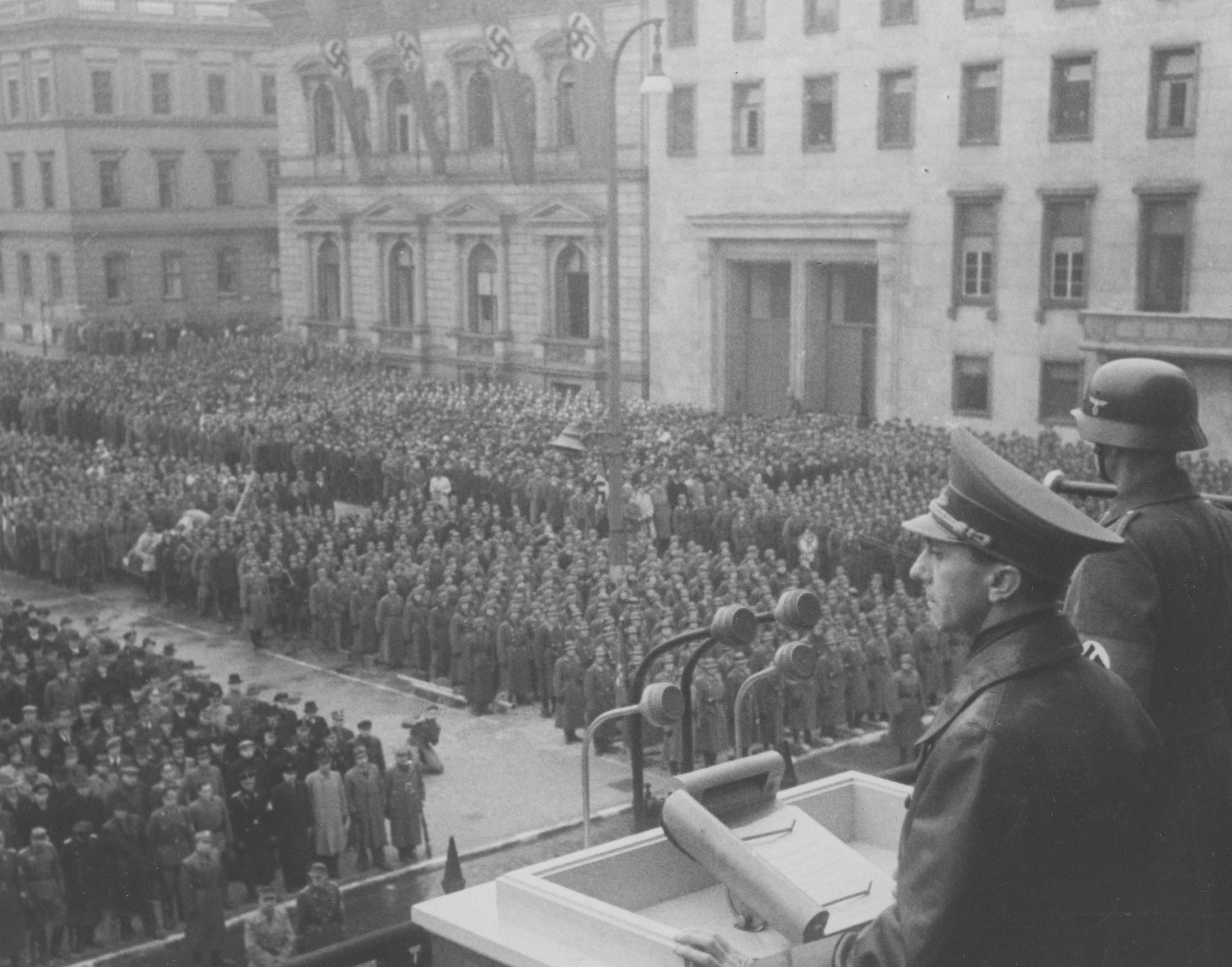 In addition to print propaganda, Goebbels (center right) incited mobs with inflammatory speeches on broadcast media and at large rallies. / Polish State Archive