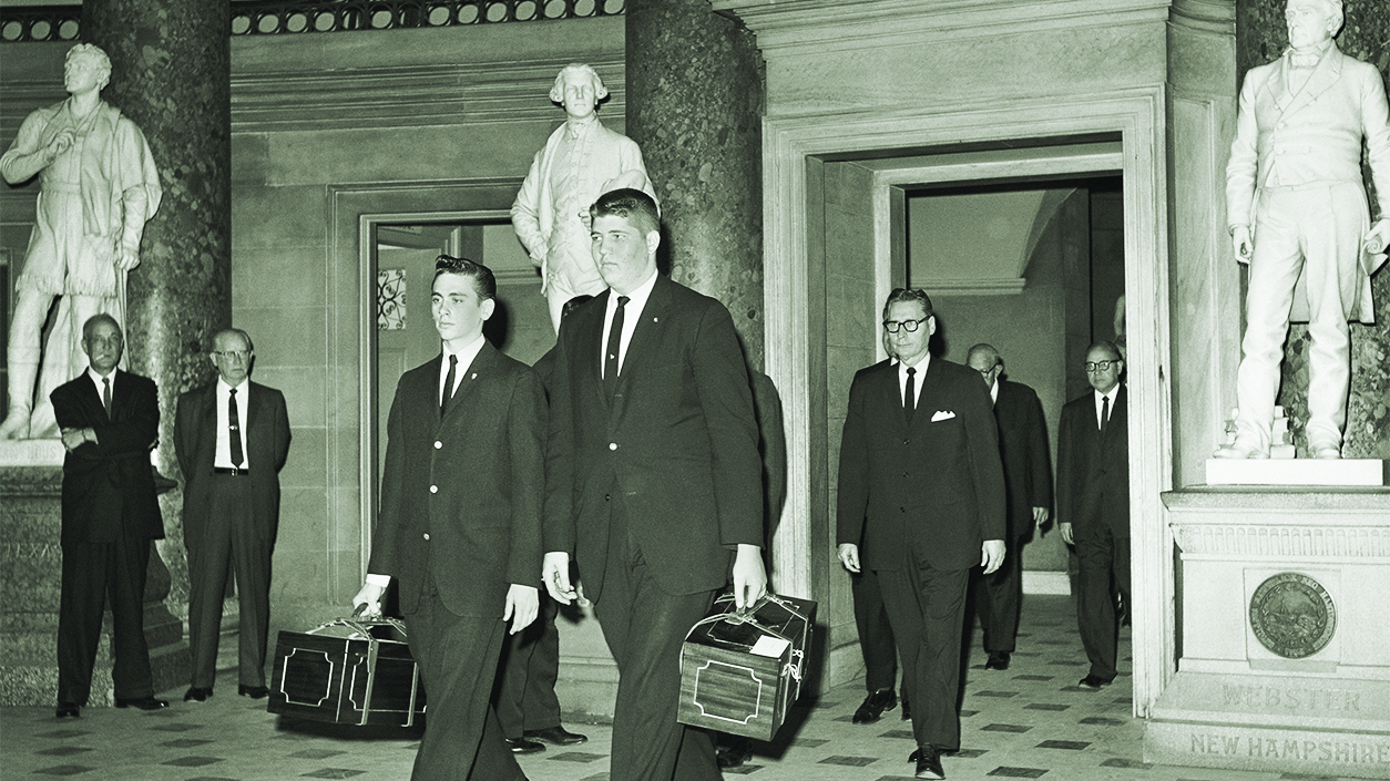 The mahogany boxes containing the Electoral College votes are shown being carried to the House Chamber on Jan. 6, 1961, by Capitol Pages Don Wilson and Tom Chapman. Following are Joseph Dukes, Senate Sergeant at Arms. (Getty Images)