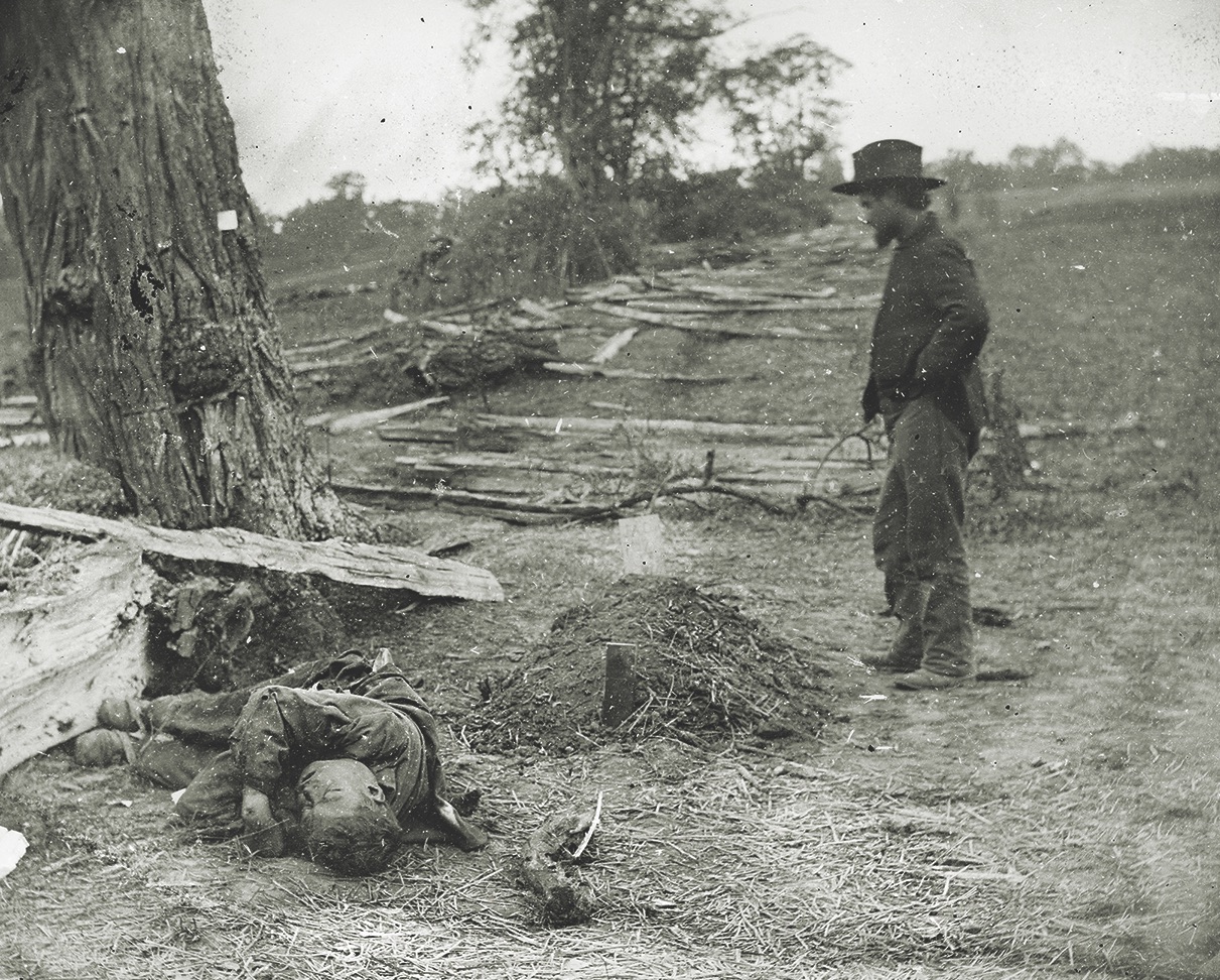 An unburied Confederate soldier lies next to the grave of Lieutenant John Clark of the 7th Michigan Infantry. Clark’s grave is marked with a simple wood board on which his name is inscribed. The lieutenant’s family recovered his body, and he is buried in Monroe, Mich. (Library of Congress)