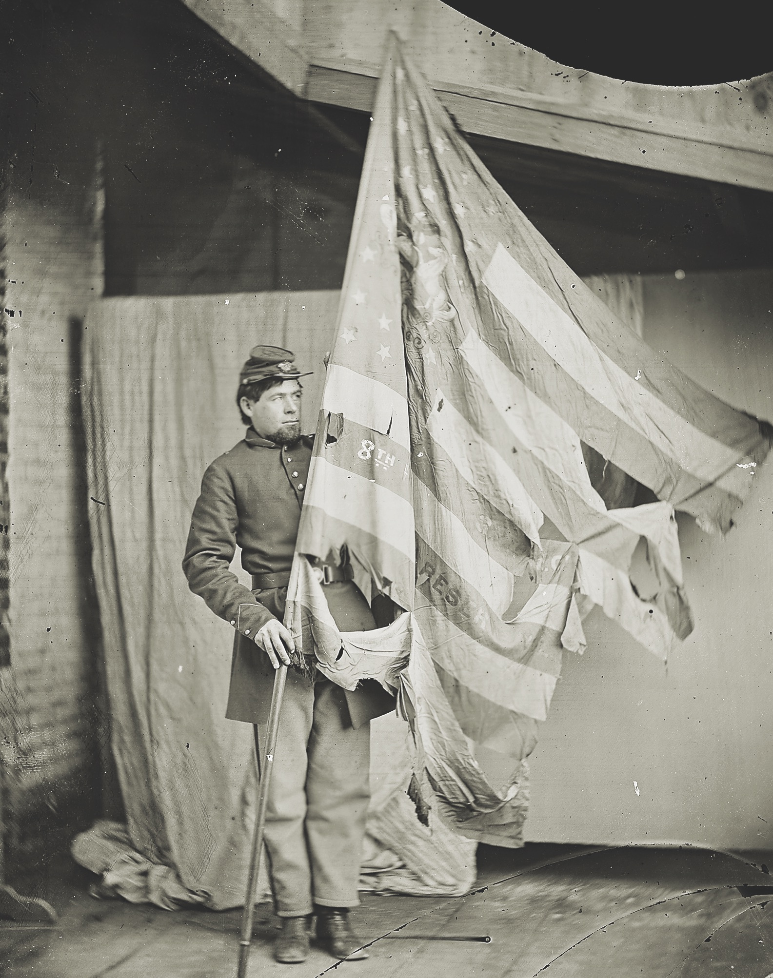 A color bearer of the 8th Reserves holds the tattered national flag of his regiment. (National Archives)
