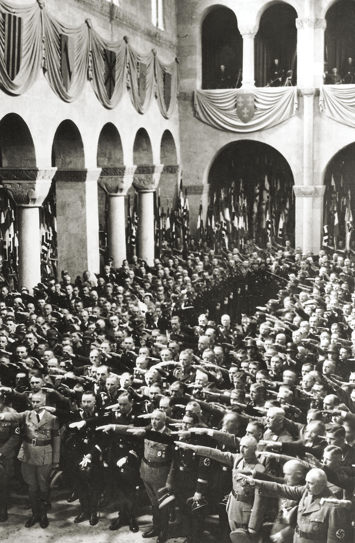 Himmler (front row, second from left) and Nazi guests perform a Hitler salute during a "worship" ceremony at the cathedral in 1936. Many Nazi officials who became infamous for crimes against humanity attended, including Holocaust architect Reinhard Heydrich, visible standing right behind Himmler.