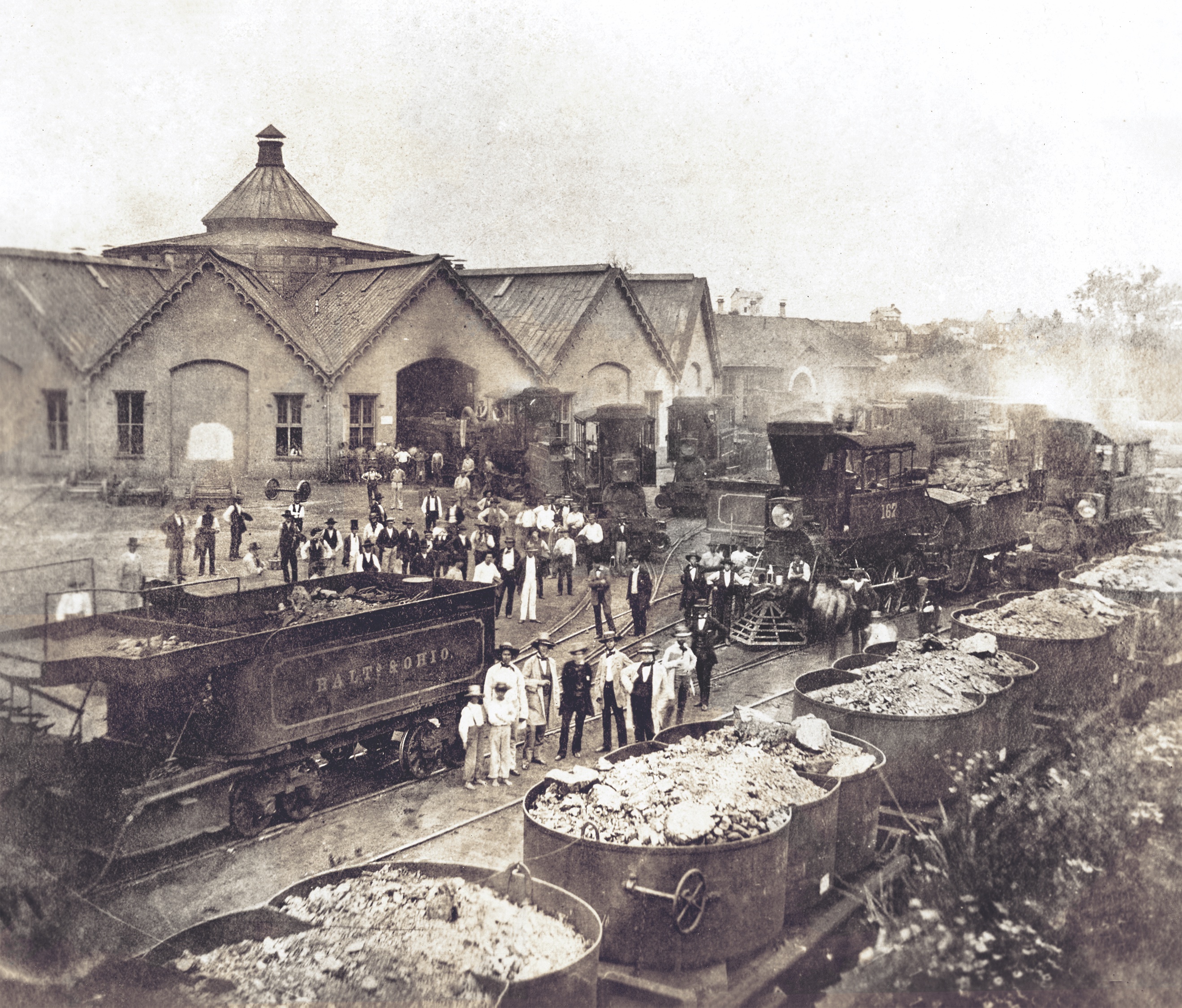 In this 1863 photograph of the B&O Railroad’s Martinsburg roundhouse, taken the year West Virginia became the country’s 35th state, workmen and bystanders pose among an assortment of Camelback locomotives and a train of iron-pot coal cars. (Photoquest/Getty Images)