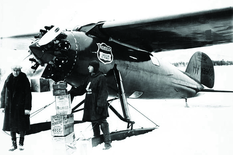 Eielsen (right) and Wilkins stand with a Lockheed Vega and supply boxes during the 1928 Detroit News Arctic Expedition. (University of Alaska, Fairbanks)