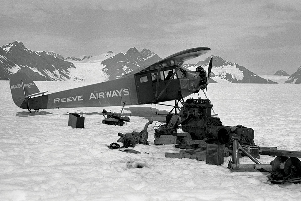 Reeve’s Fairchild 51 sits on Columbia Glacier in the Chugach Mountains with unloaded tractor engine parts for the nearby Ruff & Tuff Mine. (Russ Dow Papers, Archives and Special Collections, Consortium Library, University of Alaska, Anchorage)