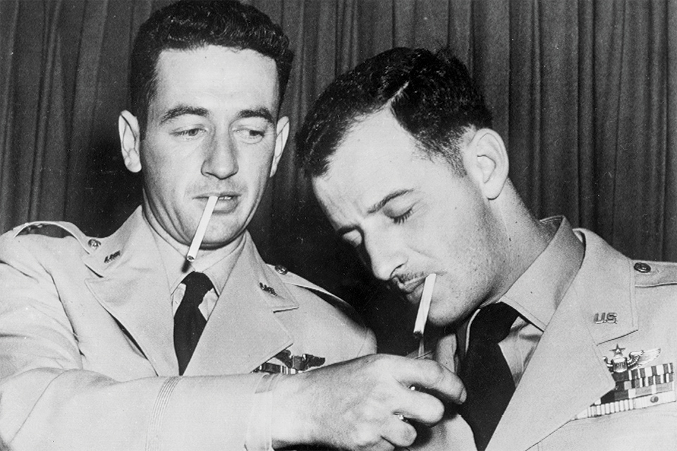 McConnell lights a cigarette for rival ace Fernandez during a Pentagon press conference after they were returned to the U.S. against their wishes. (U.S. Air Force)