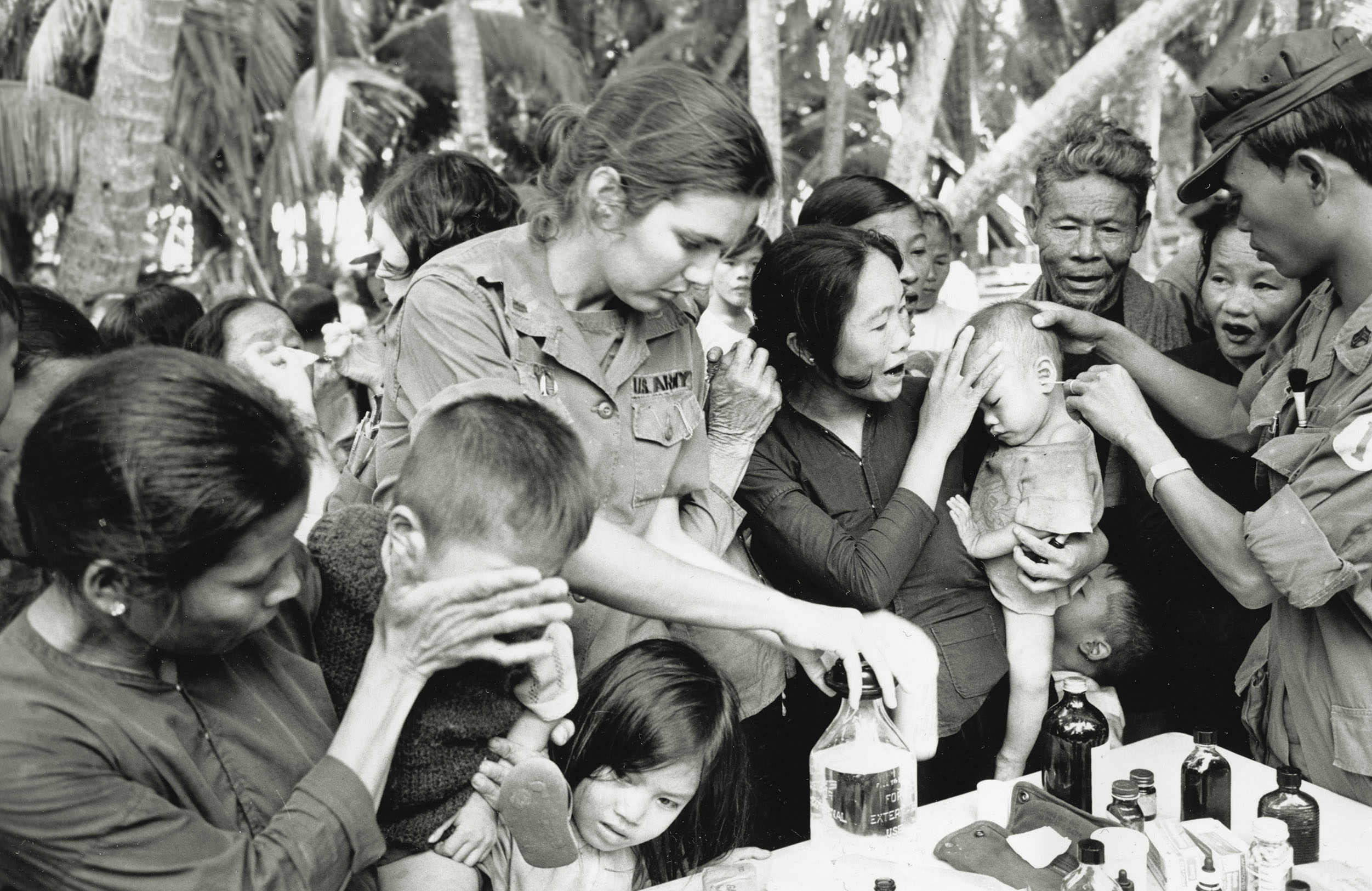 In an example of the widespread reach of U.S. military health services, Lt. Mary Huepers opens a bottle of alcohol to treat a Vietnamese villager during a MEDCAP visit to Ky Hoa Island off the coast of South Vietnam on Nov. 28, 1969. / AP