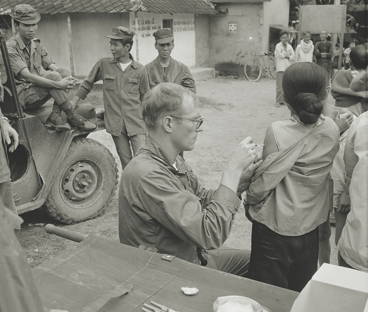 Air Force Capt. John R. Vydareny vaccinates a young Vietnamese woman against plague during a Medical Civic Action Program visit to a village near Phu Cat Air Base in central South Vietnam. Civilians suffered from war-related injuries in addition to health problems caused by living conditions in an underdeveloped country. / Alamy