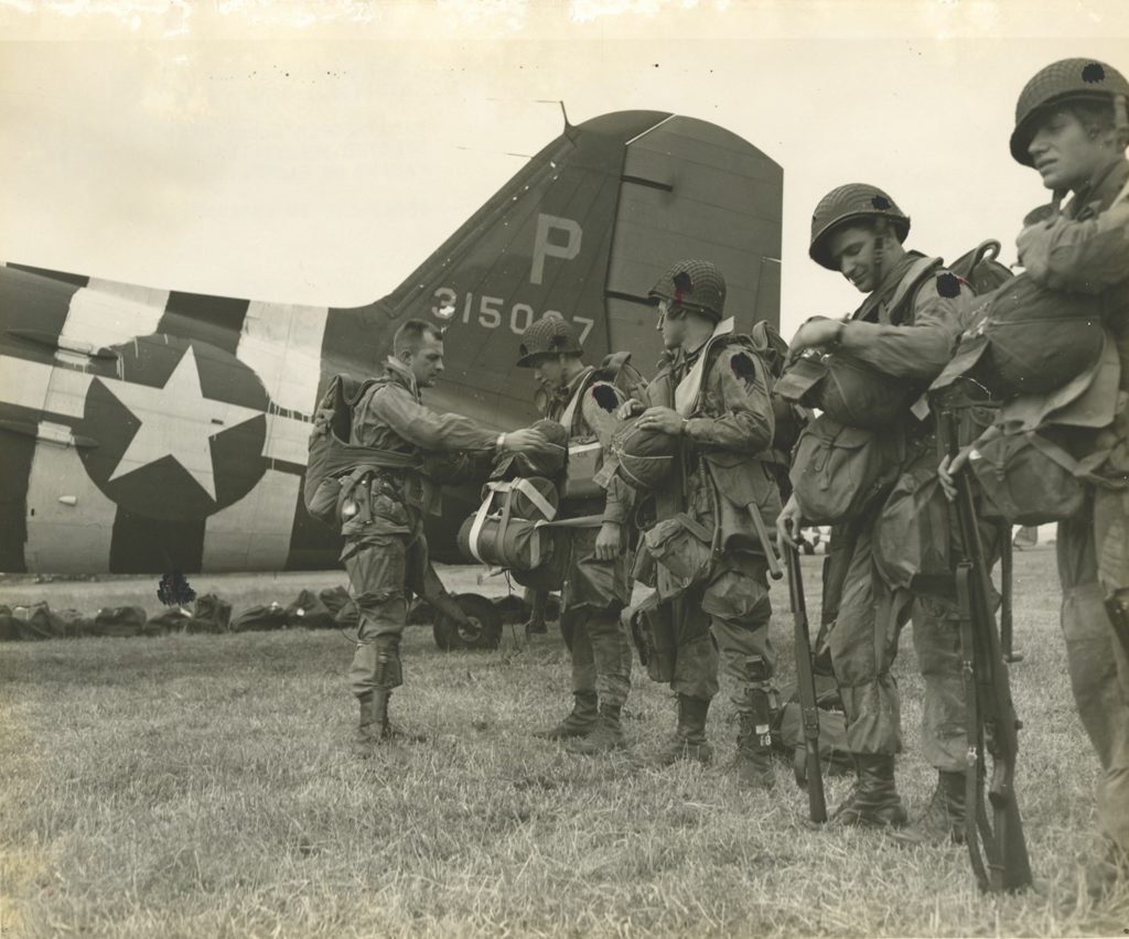 Hastily applied “invasion stripes” mark the tail of a C-47, as men of the 101st Airborne Division—their insignia concealed in this photo by wartime censors—prepare for the D-Day invasion. As with Salerno, the new safeguards proved effective. (National Archives)