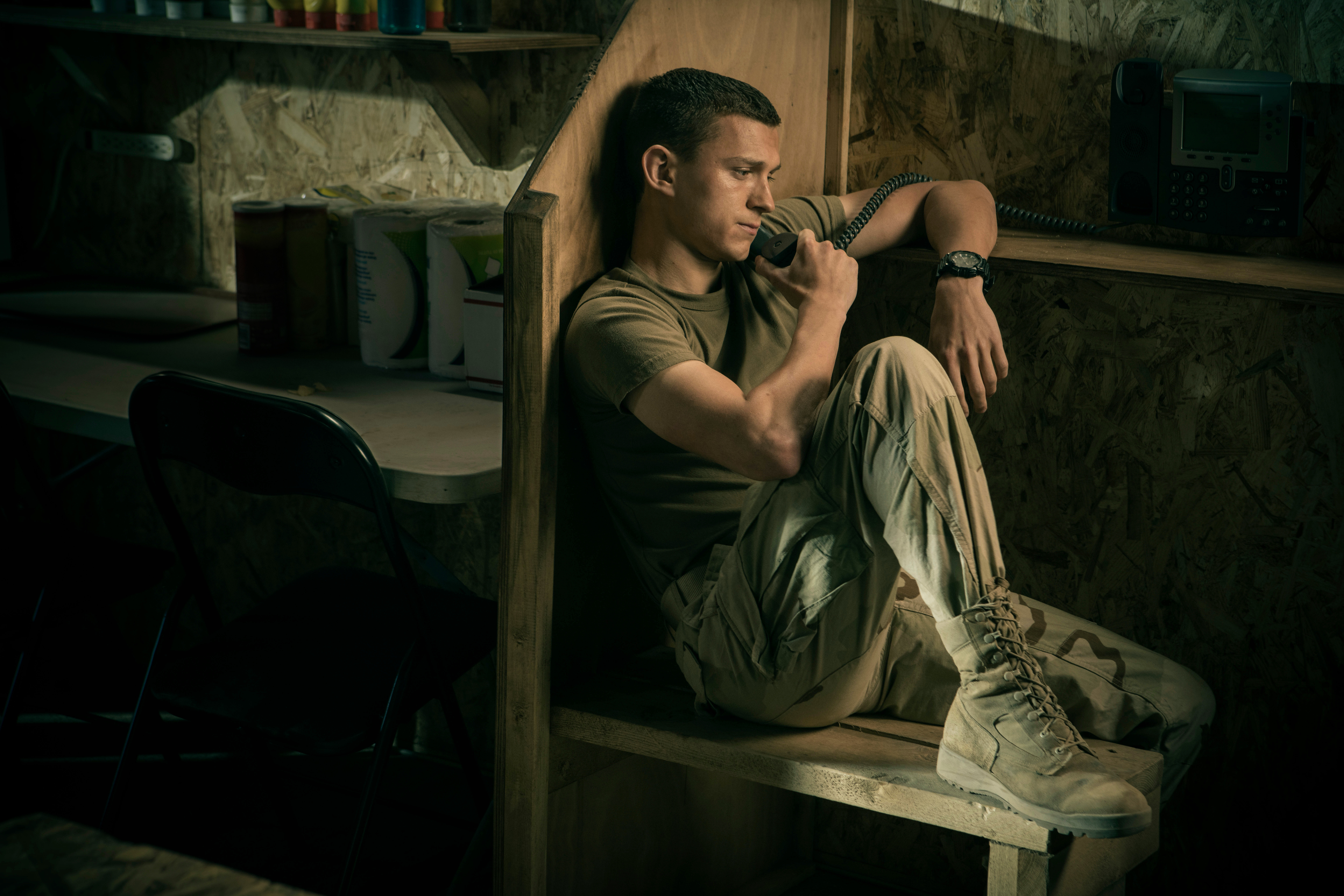 Actor Tom Holland calls home from a phone center in Iraq in a scene from "Cherry." (Apple TV+ via AP)