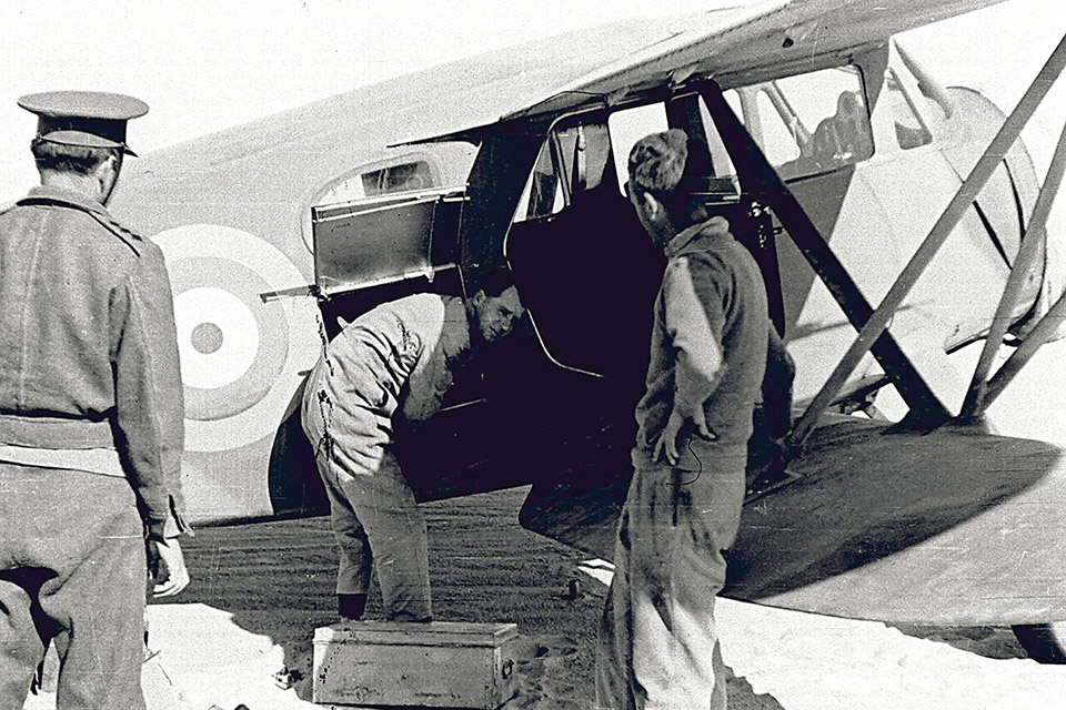 Prendergast, who with Barker piloted the Wacos, helps load one of the biplanes. (Courtesy of Gavin Mortimer)