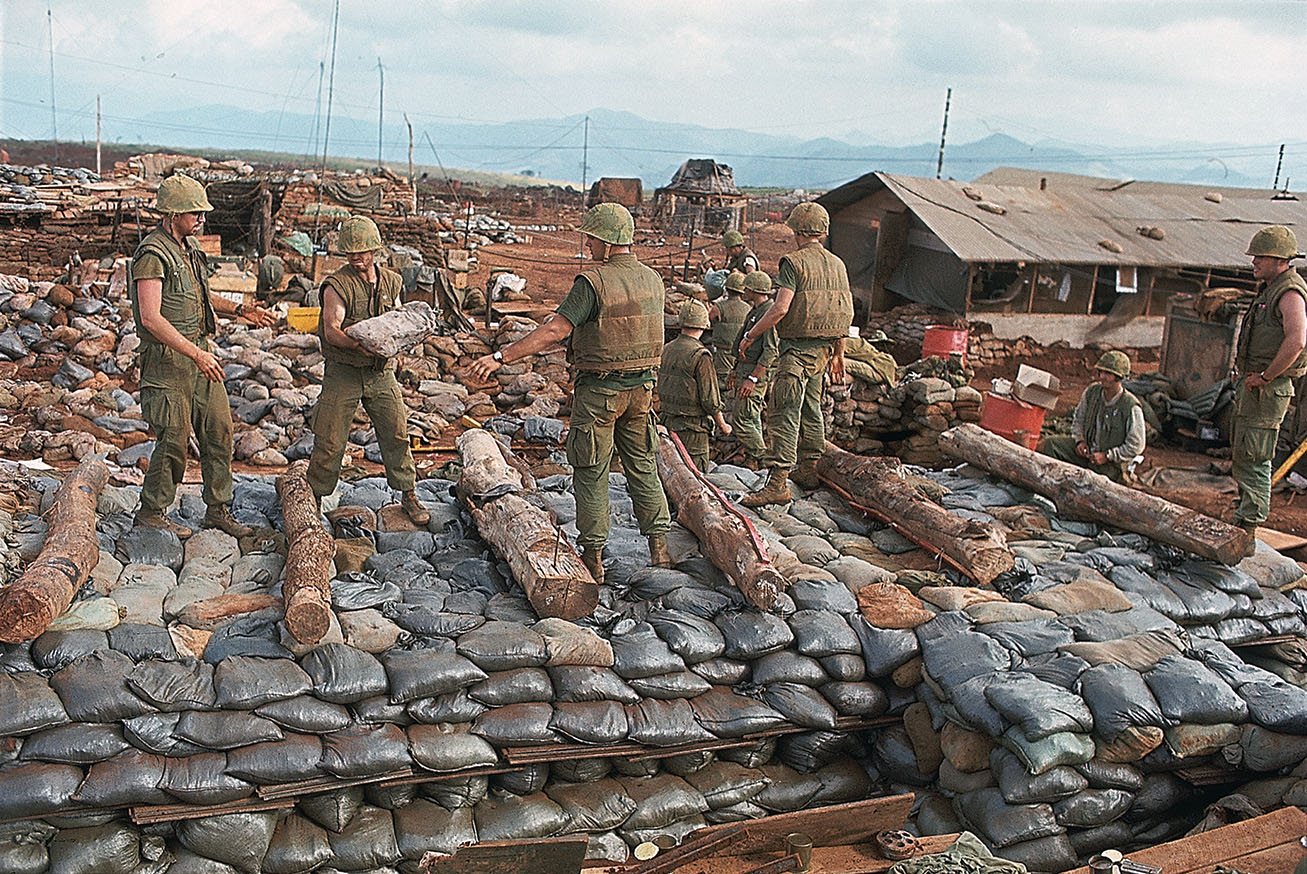 Marines inside the base haul sandbags to their bunkers. / Getty Images