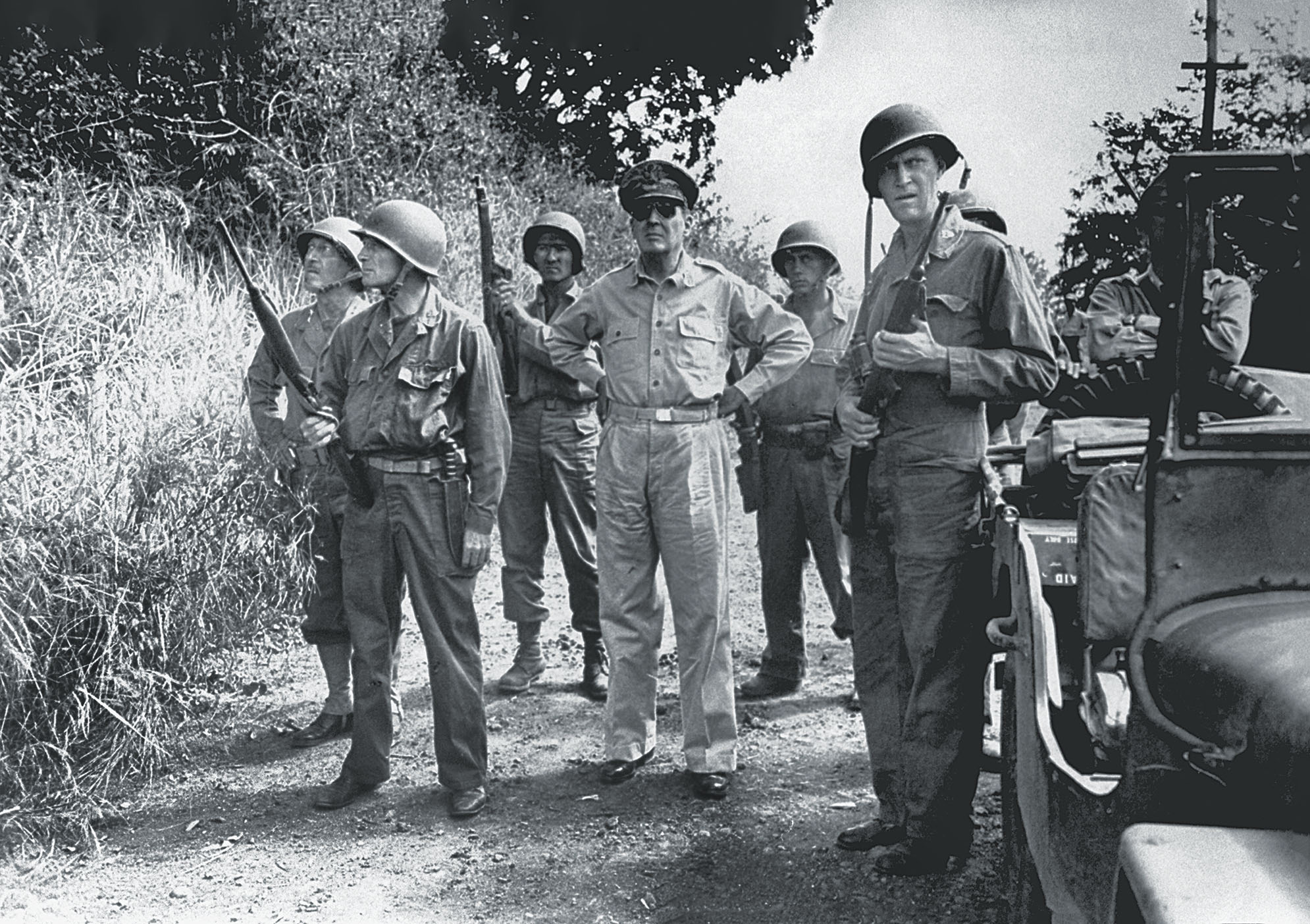Surrounded by members of his personal protective detail, General of the Army Douglas MacArthur surveys Manila before entering in 1945 / Getty Images