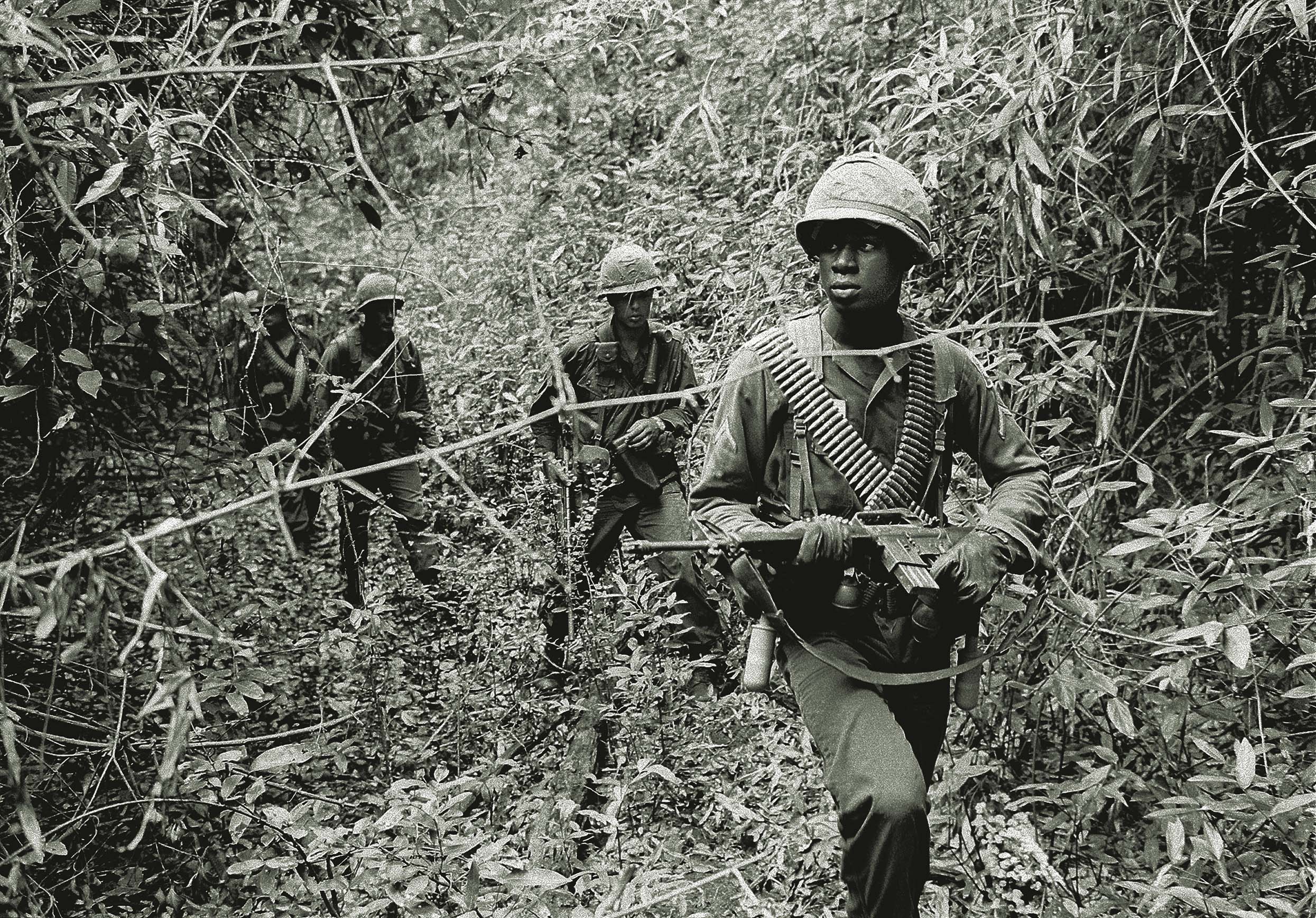 U.S. soldiers search for Viet Cong in a swampy jungle creek bed, June 1965, about 40 miles northeast of Saigon. Point men knew they were positioned to be among the first killed. / AP 