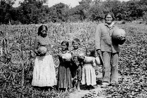 Geronimo poses with family in a melon patch at Fort Sill, where he died in captivity and was buried. (Library of Congress)