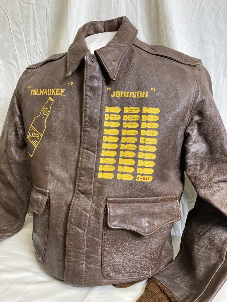 MIDWEST IS BEST: This well-preserved bomber jacket (above) belonged to decorated pilot Marshall Johnson. Johnson, below, hailed from Milwaukee, which inevitably became his nickname (note the city’s most famous product emblazoned on the leather). The name of his B-24, El Flako, stretches across the garment’s back. Johnson recorded each mission on a small emblem on his jacket; he’d go on to fly others, but the last sortie he found space for was D-Day. 