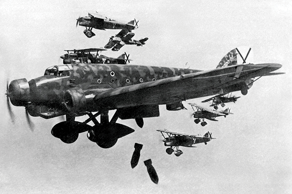 Italian Fiat CR.32 fighters accompany a Savoia-Marchetti SM.81 as it drops its bombs over Spain. (CPA Media Pte Ltd/Alamy)