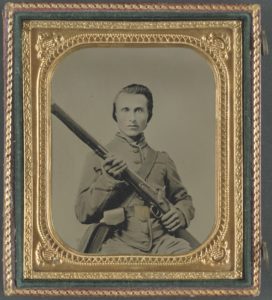 A Confederate soldier wearing a Louisiana state belt buckle brandishes his smoothbore musket, a flintlock converted to percussion.