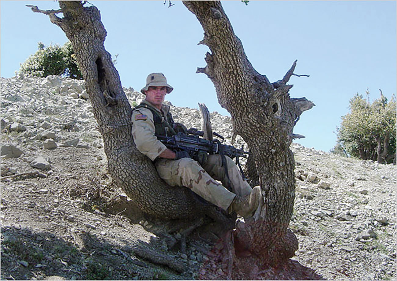 Holding his M249 SAW, Pat takes a break  after deploying to Afghanistan in April 2004. He was killed days later. / Courtesy of Marie Tillman (Associated Press)