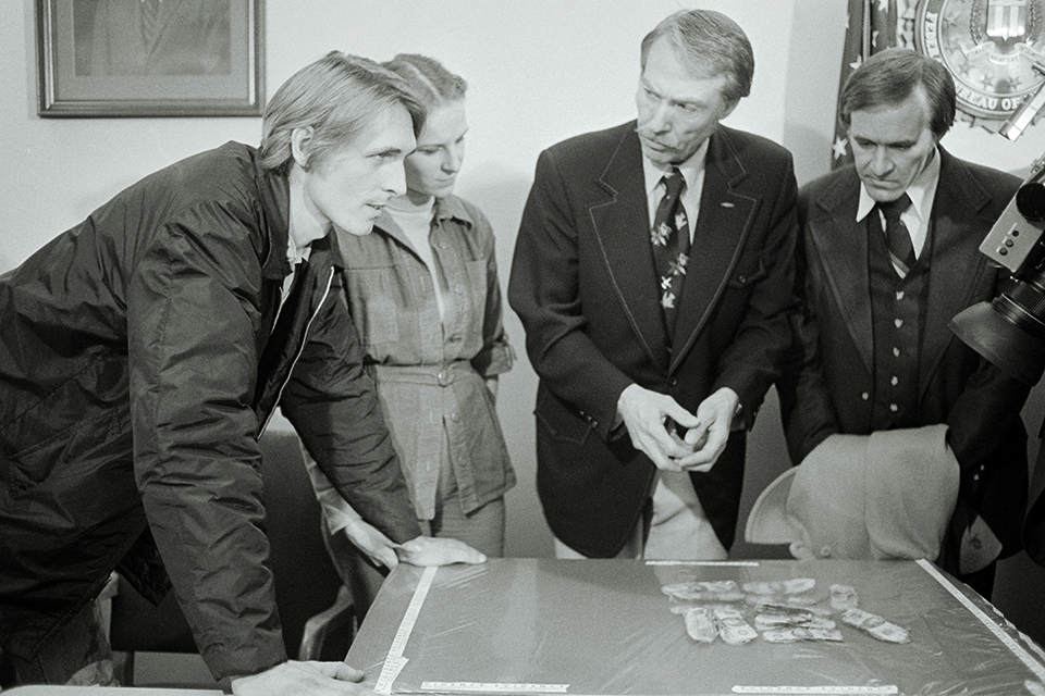 FBI agents and Howard and Patricia Ingram (left) examine the money their son Brian found in 1980. (Bettmann/Getty Images)