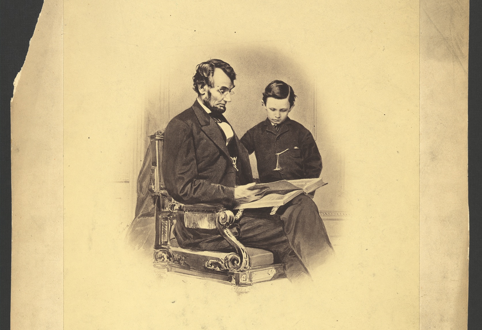 President Abraham Lincoln reads from a large Bible to his son, Tad. (Library of Congress)