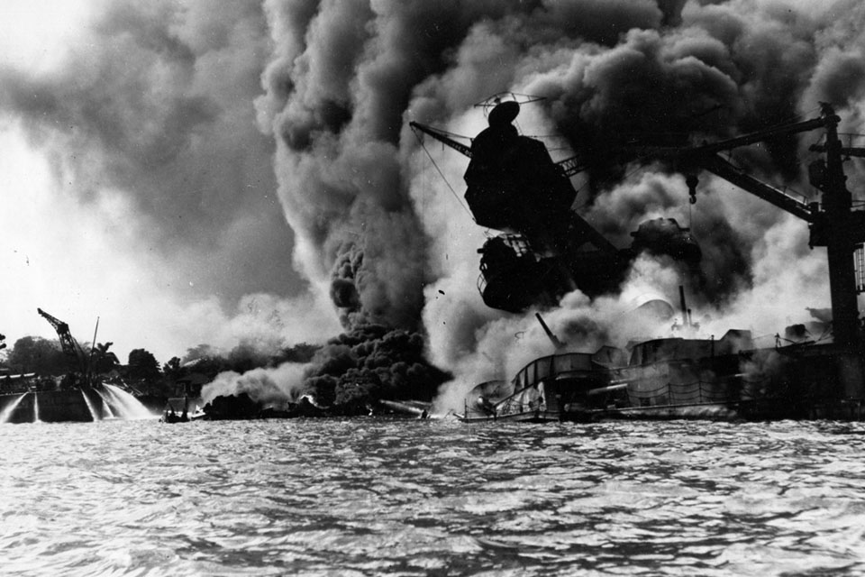 On December 7, 1941, the USS Arizona was moored inboard of the repair ship Vestal when the Japanese struck Pearl Harbor. “The massive explosion that followed,” according to the Naval History and Heritage Command, “has never been fully explained, since the bomb apparently did not pierce Arizona's armored deck, which protected her magazines.” Over 1100 of her crew were killed, and the battleship was considered a total loss, settling at the bottom of the harbor. Sailors of the USS Tennessee can be seen at left, directing fire hoses on the oil slicked water to force flames away from their ship. The startling photo of the USS Arizona engulfed in flame swiftly became a rallying cry for the nation to “Remember Pearl Harbor.” One day after the attack the United States was at war. (Naval History and Heritage Command)