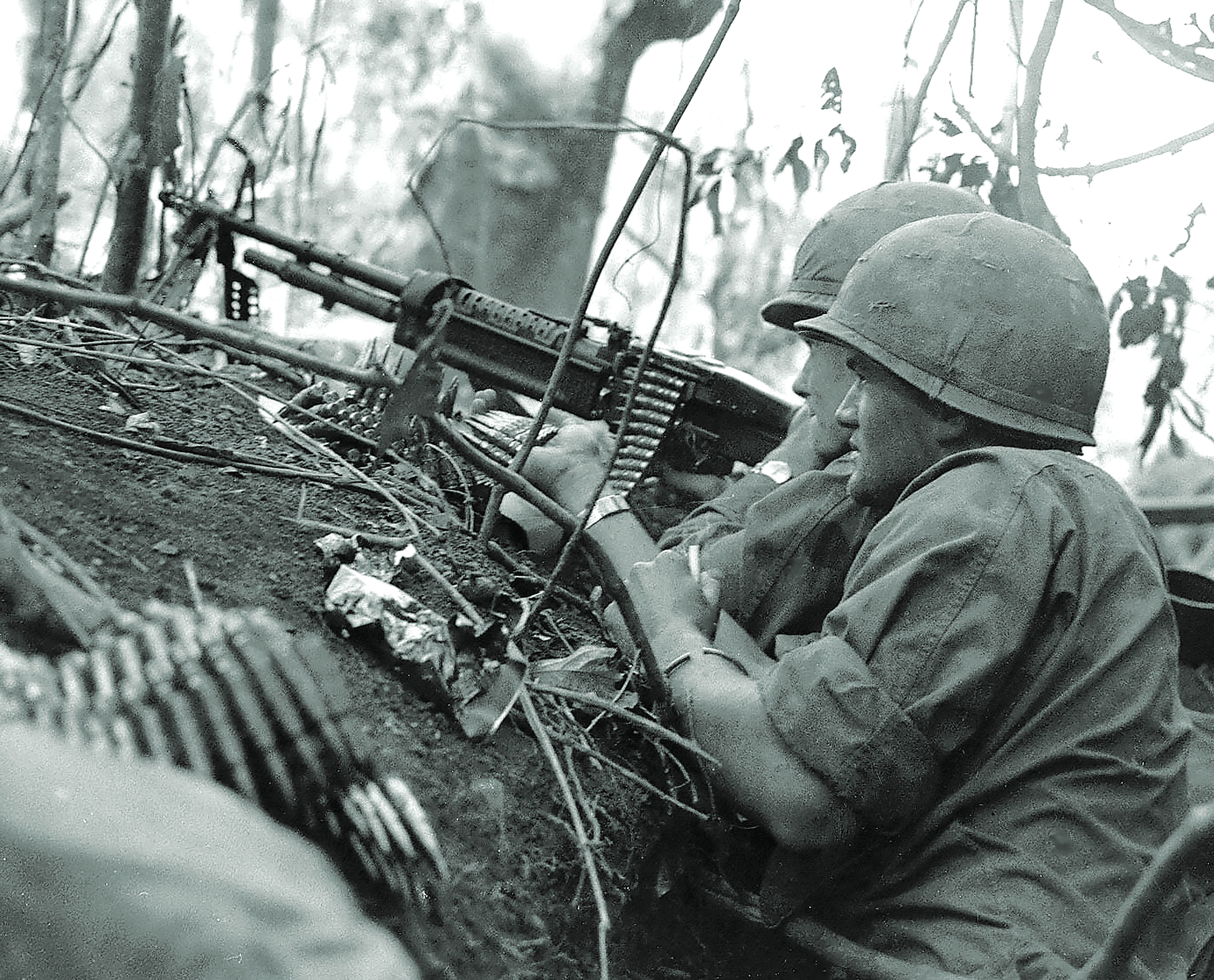 U.S. soldiers nestled in dense jungle foliage provide covering fire with an M60 machine gun in 1966. Machine gunners were often in positions exposed to enemy fire and had short life expectancies after the first shot in a firefight was fired. / Alamy
