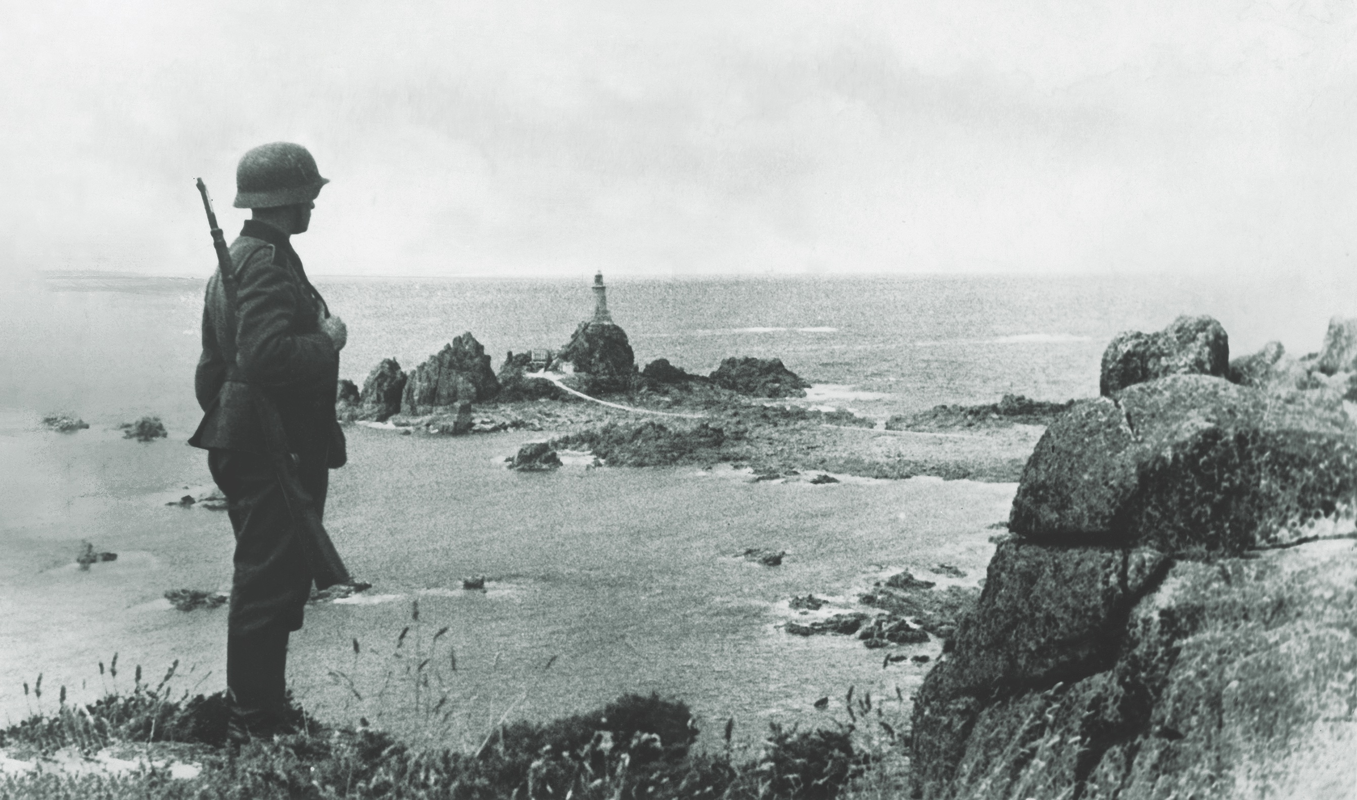A Nazi propaganda photo depicts a Wehrmacht soldier standing watch on La Corbière (“a place where crows gather”), off the coast of Jersey, in 1944. (Ullstein Bild DTL/Getty Images) 